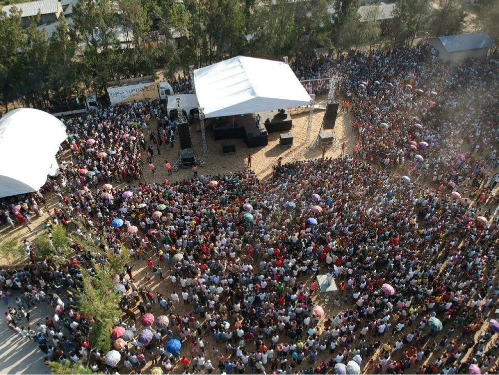 An aerial historic view of a dense Joshua Campaign crowd around the stage