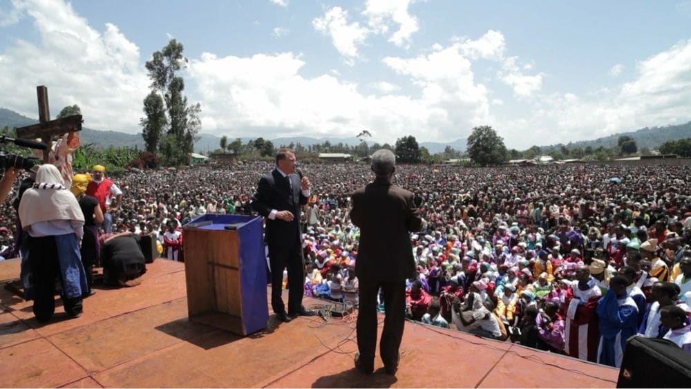 Karl Härgestam at the pulpit with an interpreter before a massive crowd