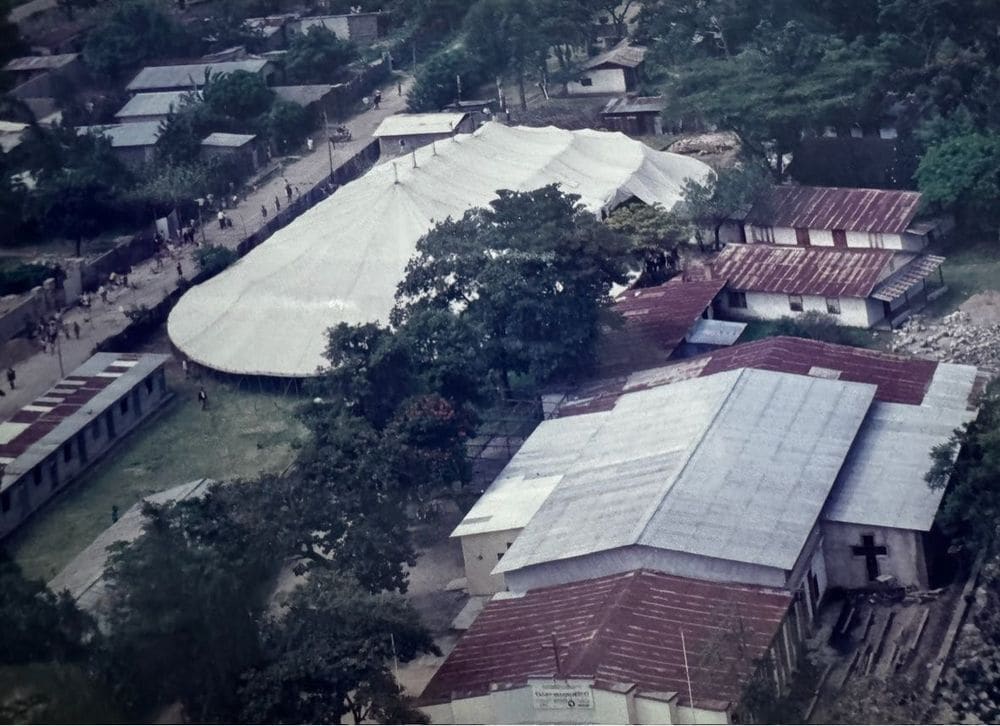 Aerial view of a large white Joshua Campaign tent in a village